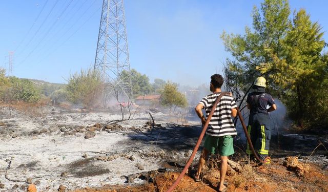 Evinin etrafını saran alevlere gözyaşları içinde hortumla müdahale etti